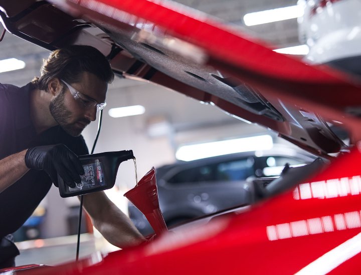 Technician pouring Oil